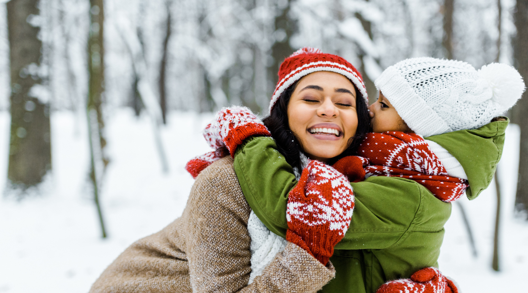 mother hugging daughter in snow